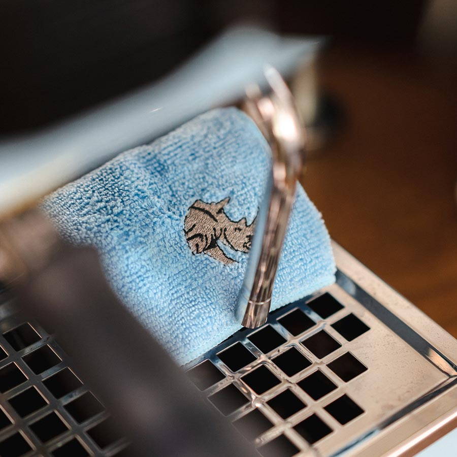 Rhinowares Barista Cloth in blue lying on a espresso machine.