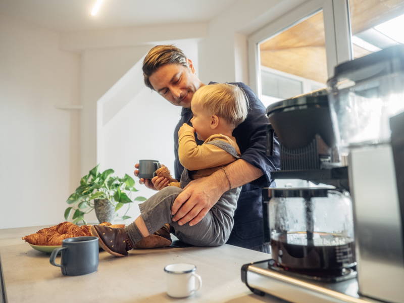 Vater mit Kind am Frühstücken mit Kaffee