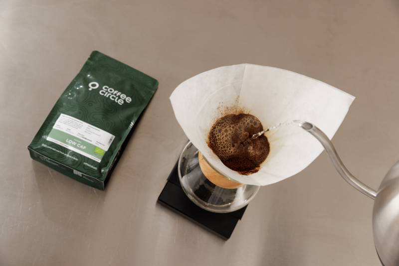 Feuchte das im Filter befindliche Kaffeepulver nun zunächst gleichmäßig mit einer kleinen Menge Wasser in kreisförmigen Bewegungen an. Ziel ist dabei, dass das gesamte Pulver durchweicht wird, gleichzeitig aber noch möglichst wenig Kaffee durch den Filter hindurch tropft. Du wirst sehen, wie der Kaffee in den folgenden 30 Sekunden zu quellen beginnt (der sogenannte „Bloom“).