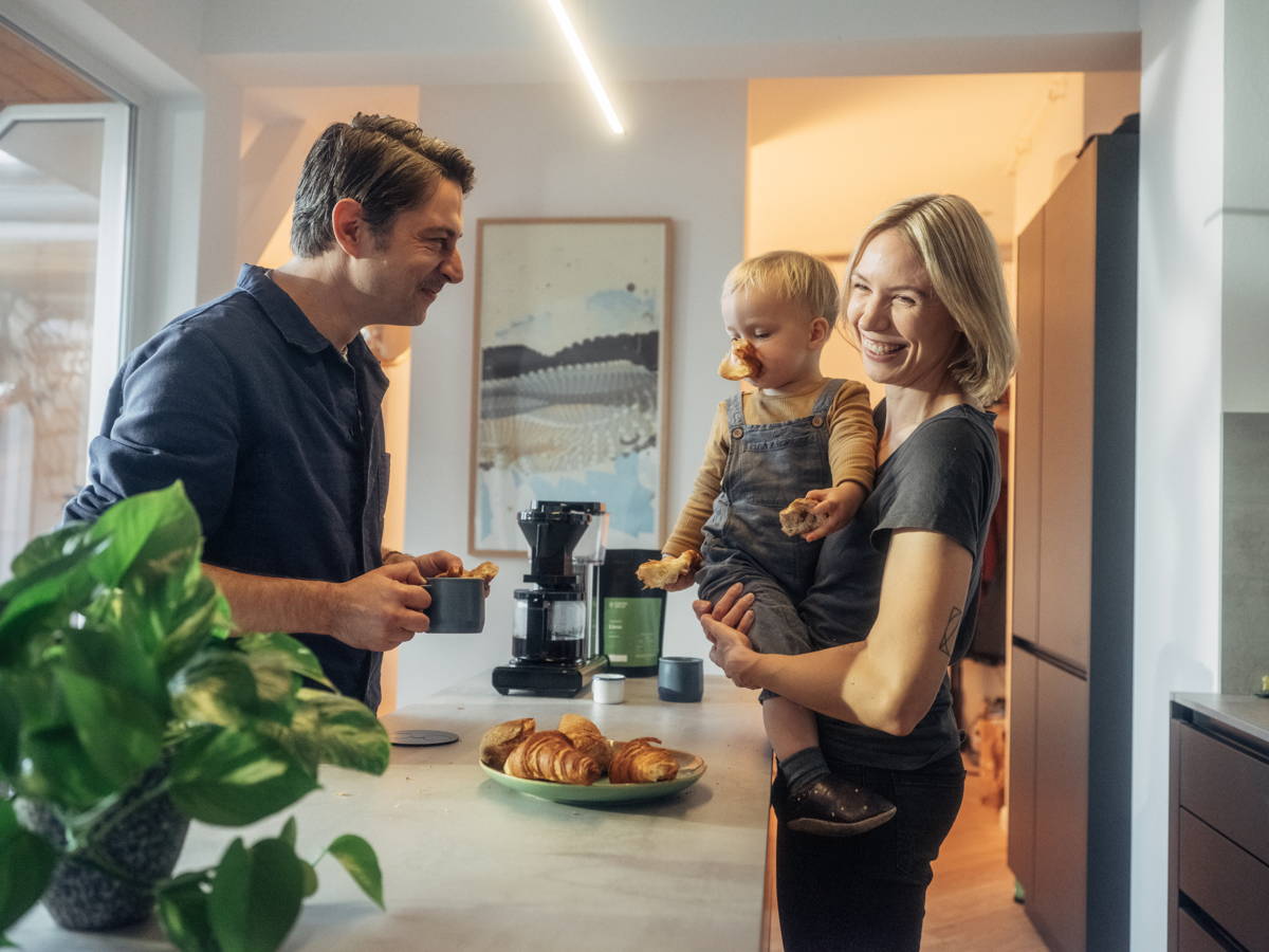 Familie mit Kind am Frühstücken mit Kaffee