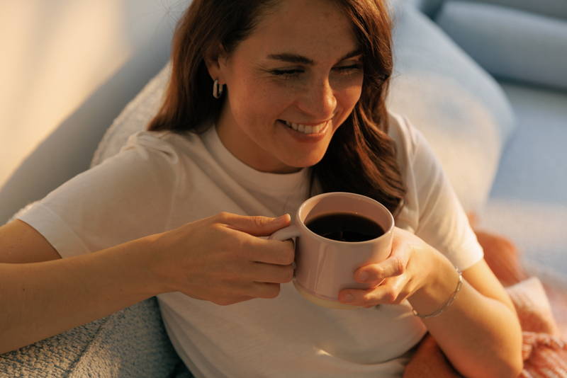 Woman sitting on a sofa, holding a cup of coffee