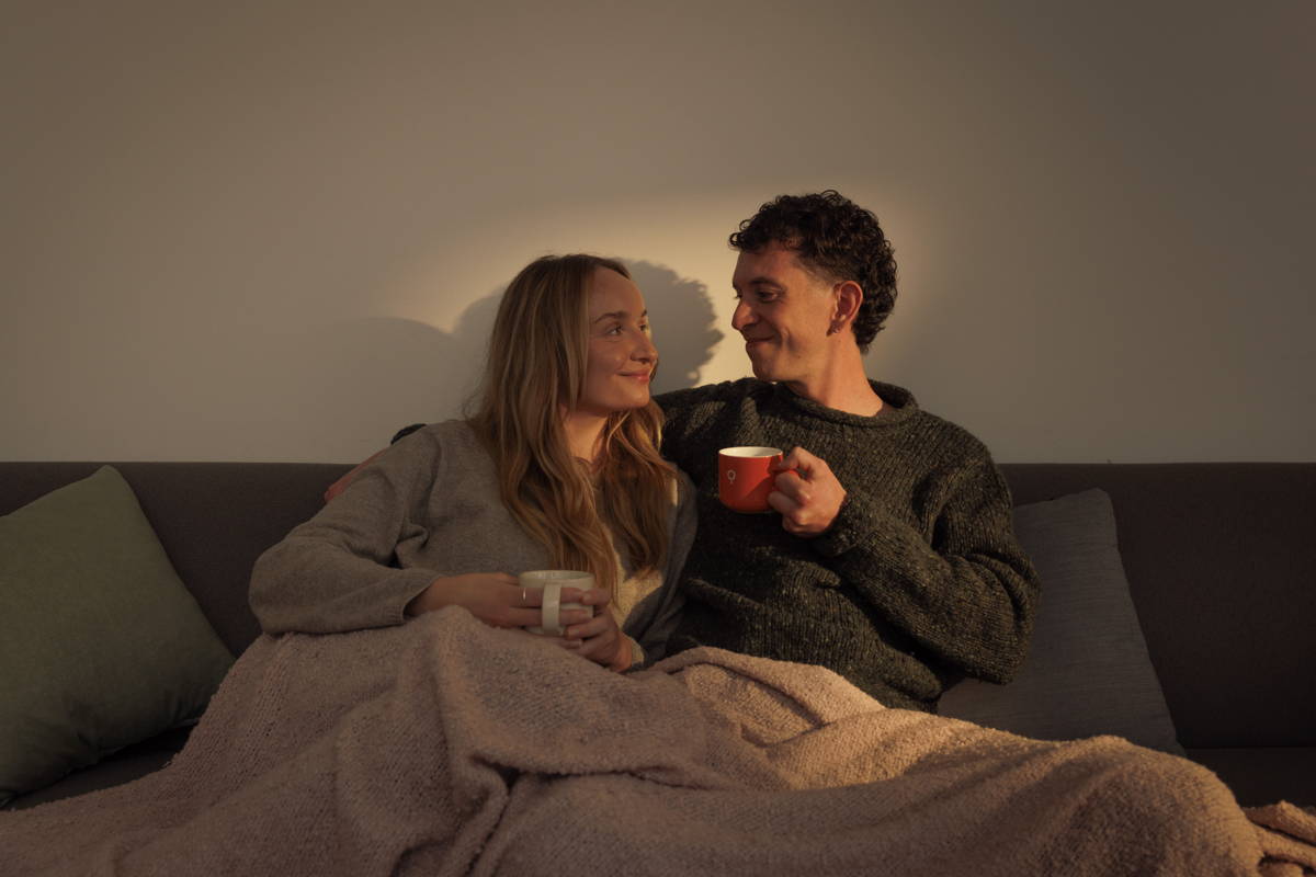 Ein Paar genießt Kaffee zusammen auf der Couch.