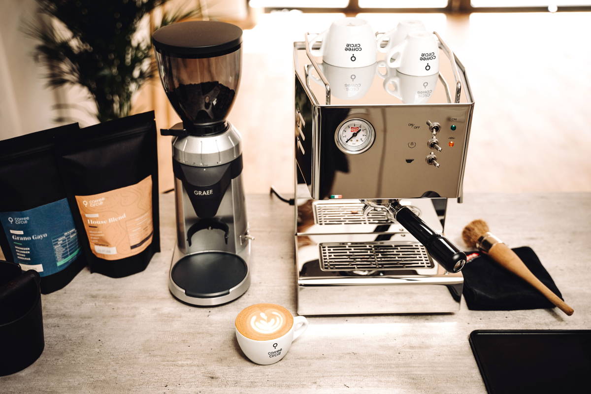 House Blend und Grano Gayo Espresso neben Graef Mühle und QuickMill Orione Espressomaschine und Cappuccino