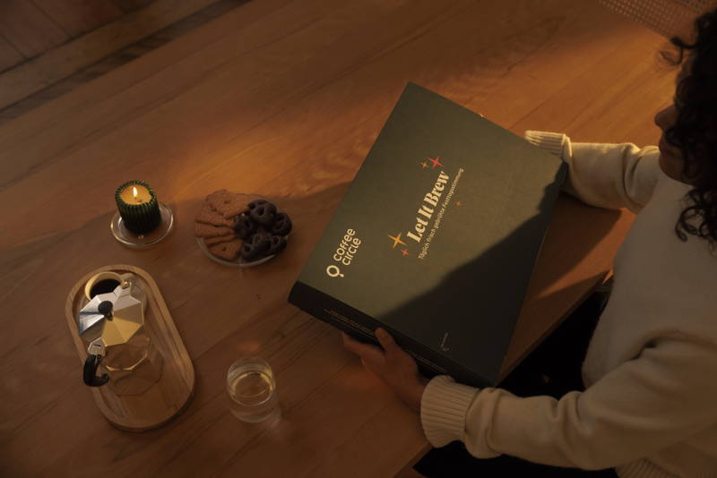 Eine Frau hält einen Adventskalender, auf dem Tisch steht eine Bialetti