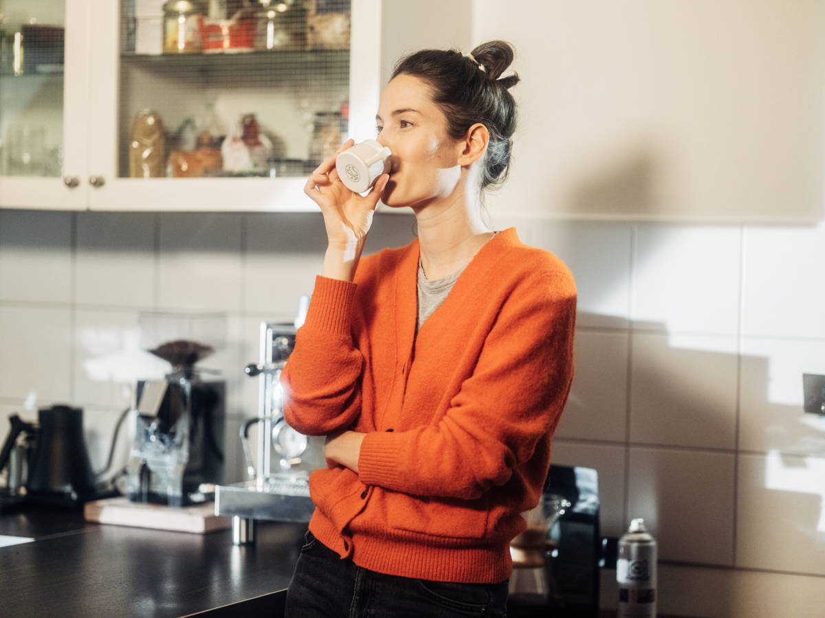 Anna beim Kaffee trinken in der Küche.