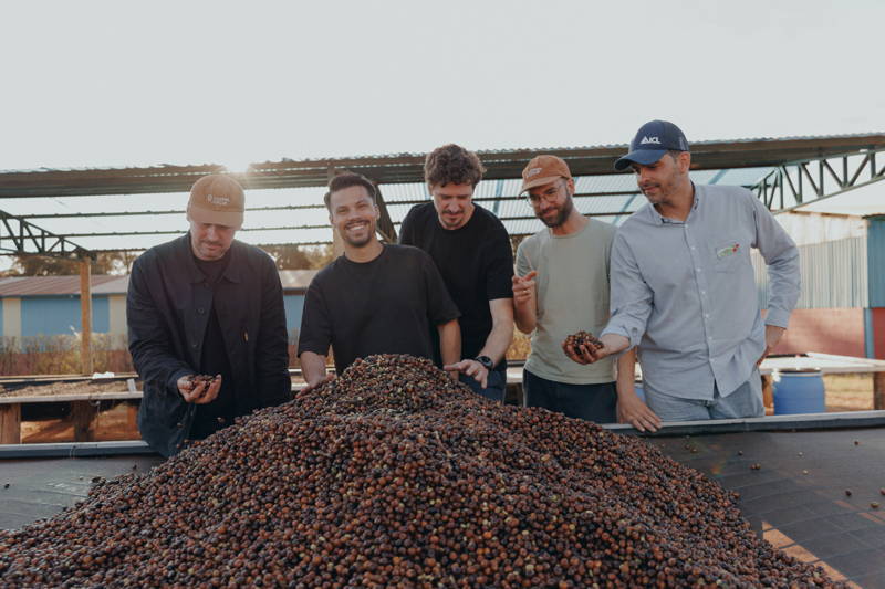 Martin, Hannes und Robert mit Kaffeefarmern vor Kaffeekirschen bei Daterra 2025