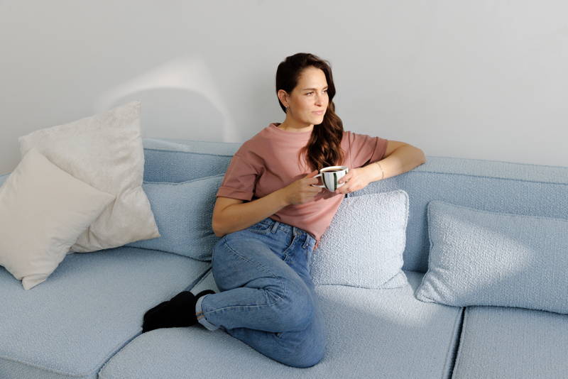 Woman sitting on a sofa, holding a cup of coffee