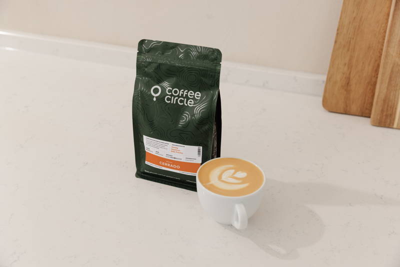 Tasse mit Latte Art neben Cerrado