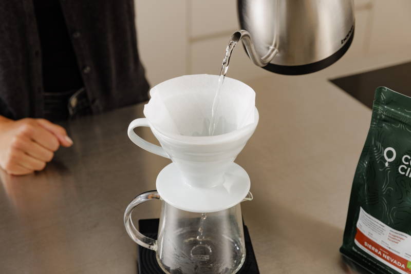 Spüle heißes Wasser durch den Filter, um den geringen Eigengeschmack des Papierfilters zu entfernen und die Kanne vorzuwärmen. Schütte das Wasser anschließend aus.