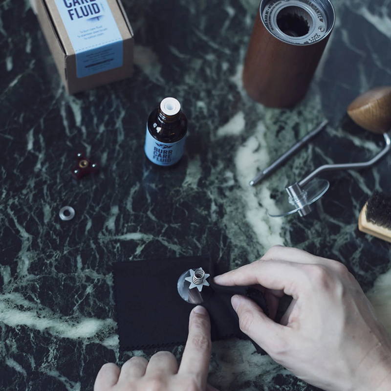 The various parts of the Comandante grinding disc care set can be seen on a marble surface.