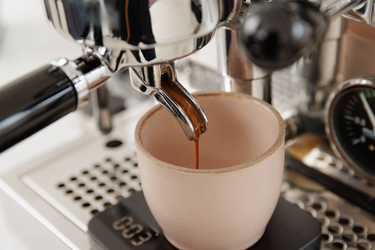 Espresso läuft aus Siebträger in Tasse
