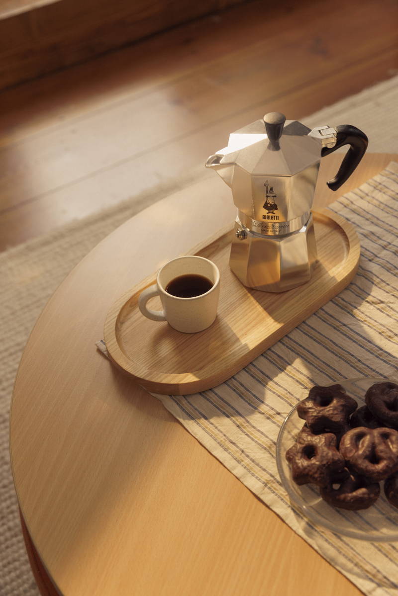 Eine gefüllte Espressotasse steht neben einer Bialetti Herdkanne.