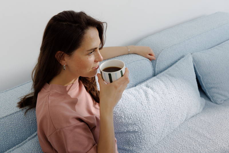 Woman sitting on a sofa, holding a cup of coffee