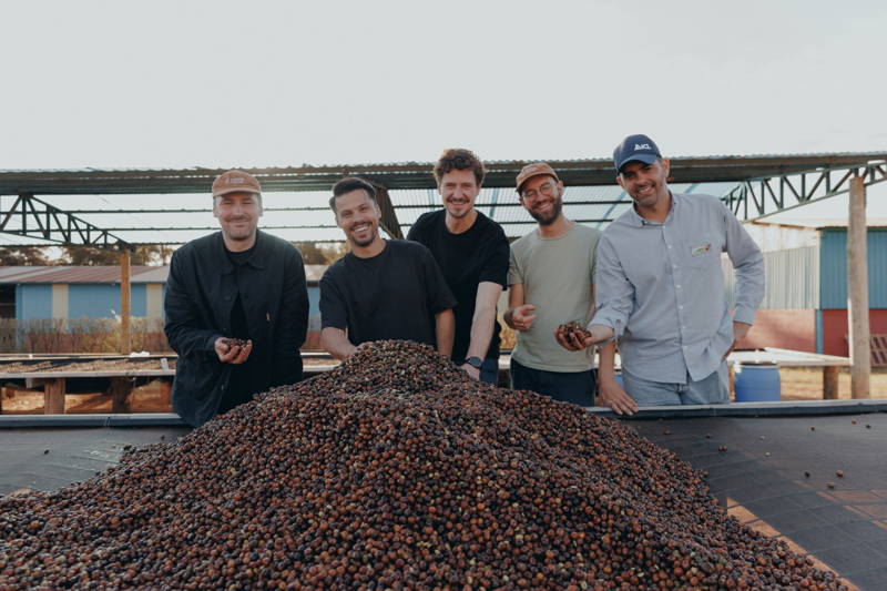 Martin, Hannes und Robert mit Kaffeefarmern vor Kaffeekirschen bei Daterra 2025