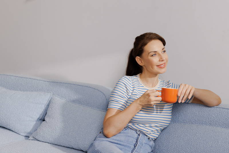 Woman sitting on the couch with a coffee in her hand
